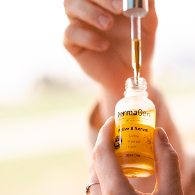 Person holding a bottle of permaGen serum with a blurred background