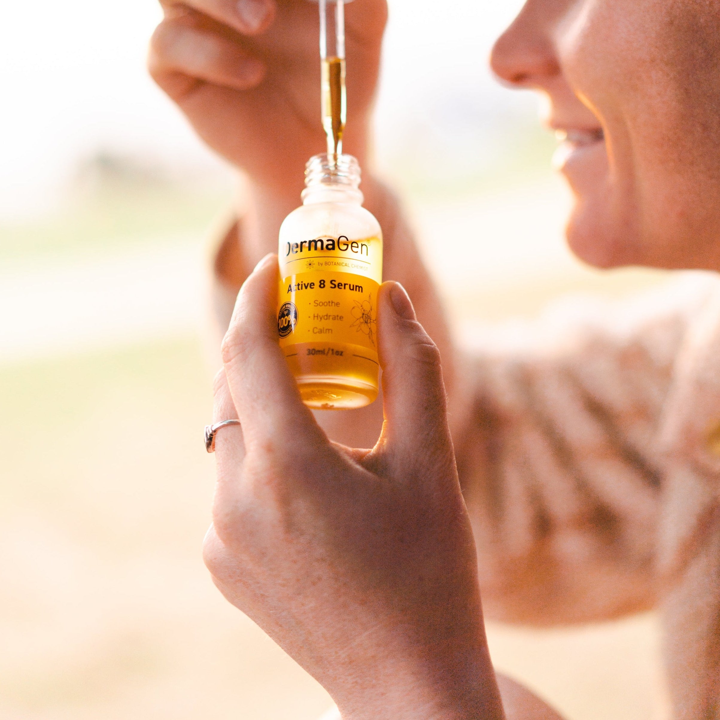 Woman holding a bottle of serum with a blurred background