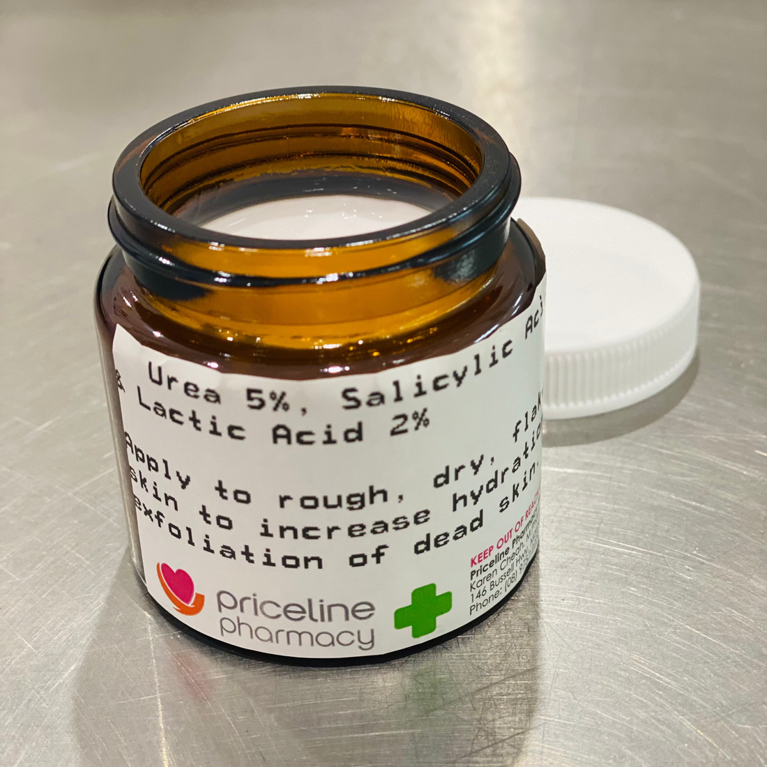 A small brown jar with a white lid labeled as &